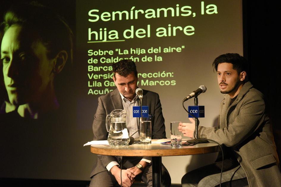 Dos personas sentadas frente a una mesa.