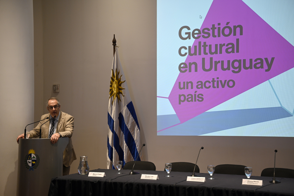 Plano general de la sala con la intervención del ministro desde un atril