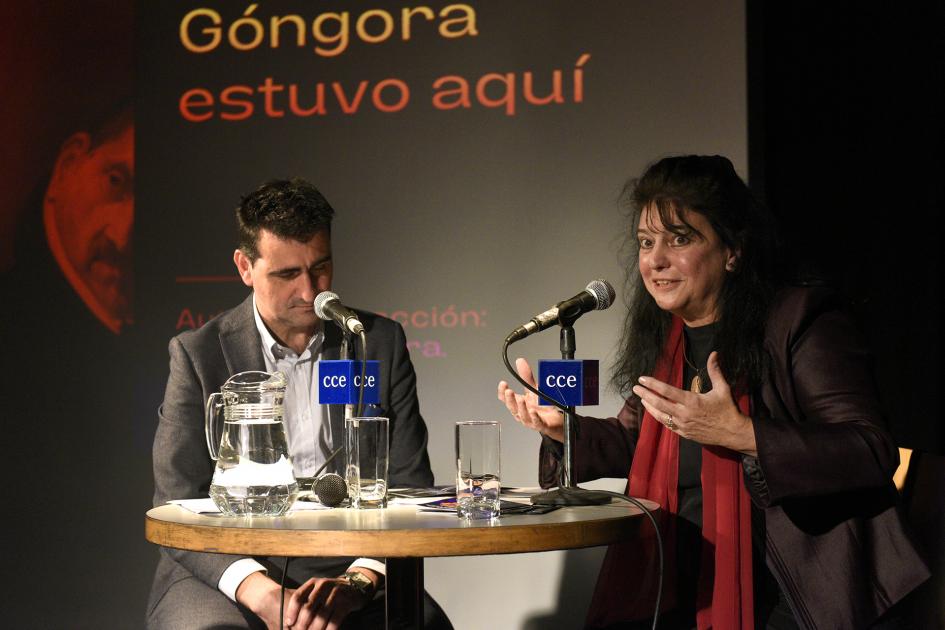 Dos personas sentadas frente a una mesa.