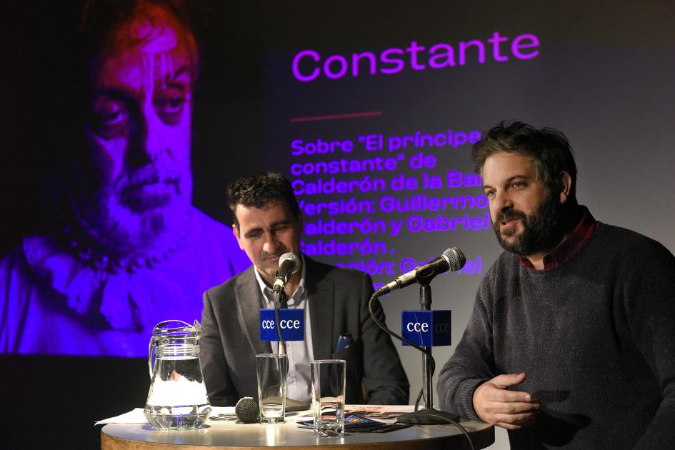 Dos personas sentadas frente a una mesa.