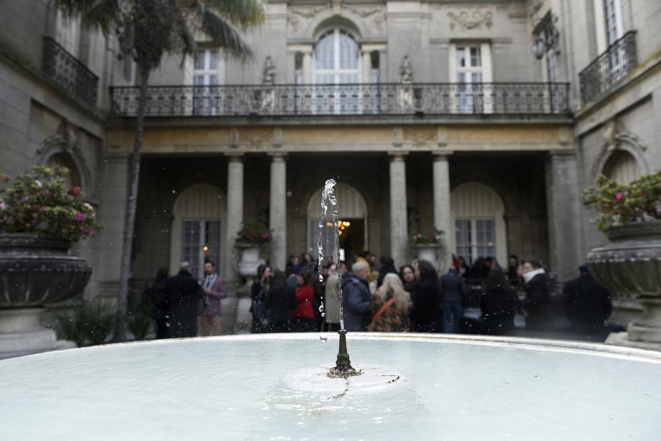 Primer plano un chorro de agua y al fondo personas 