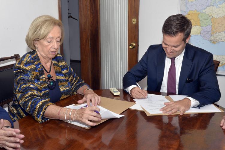 Ministra y embajador durante la firma del memor&aacute