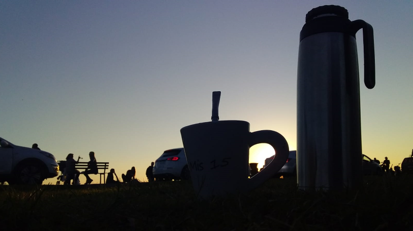 Mate y termo en el paso con atardecer de fondo