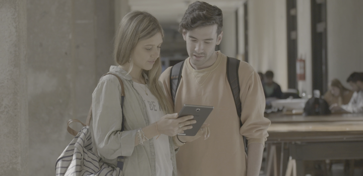 dos personas de pie hablando con tablet en la mano
