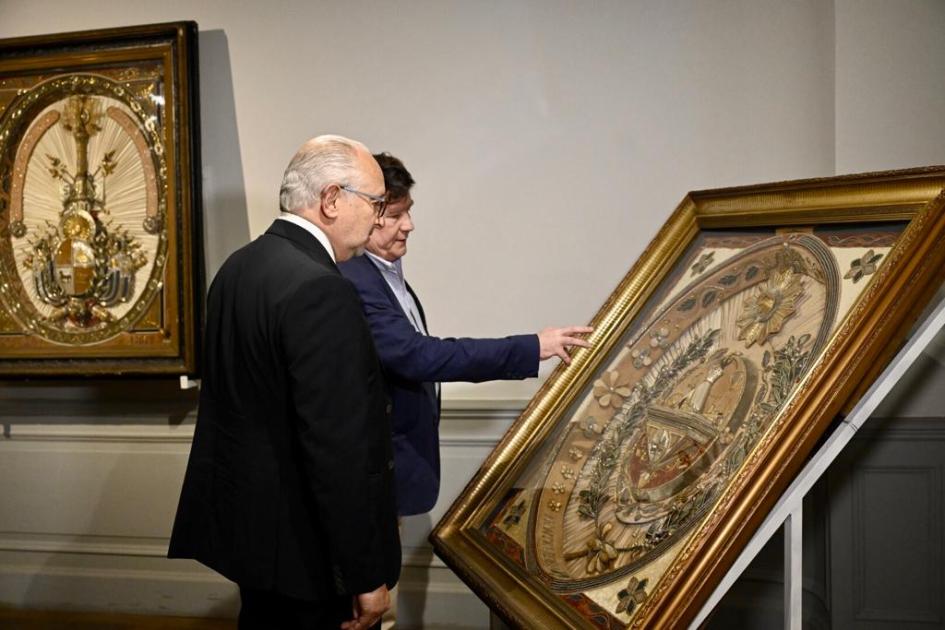Director general de la CPCN, William Rey Ashfield y ministro Pablo da Silveira. Personas hablando y mirando uno de los escudos.