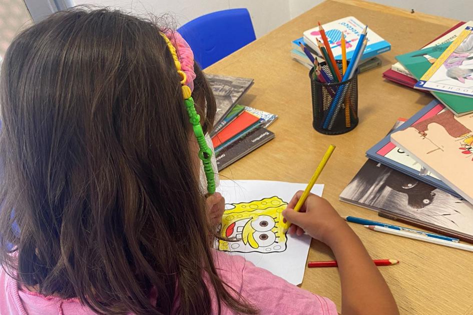 Biblioteca infantil a la sala de vacunación del Hospital Saint Bois niño en mesa con libro