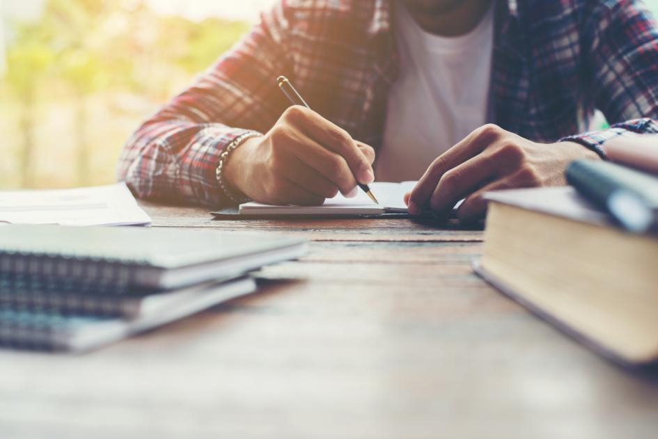 Teleo Hombre escribiendo en un cuaderno