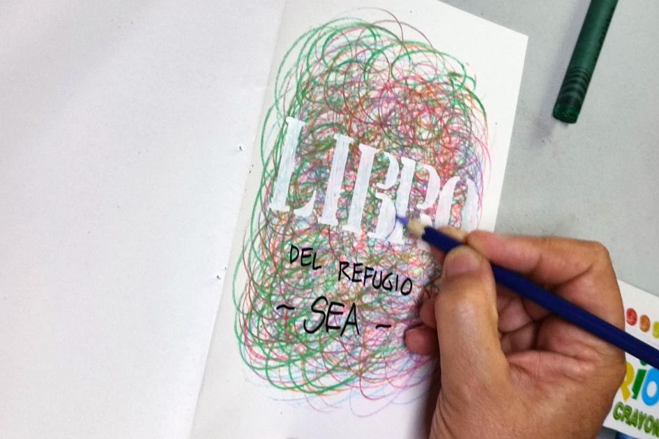 Mano con lápiz de color trabajando la tapa del libro. Mano con lápiz de color trabajando la tapa del libro.
