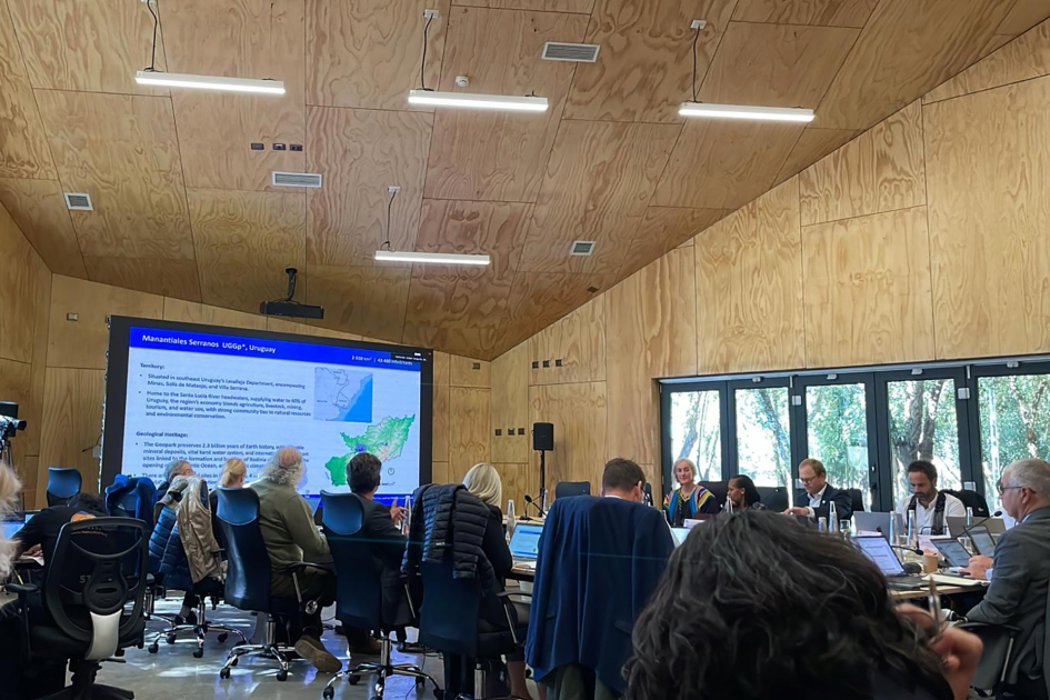 Reunión en sala con pantalla que muestra presentación sobre Geoparque Manantiales Serranos en Urugua