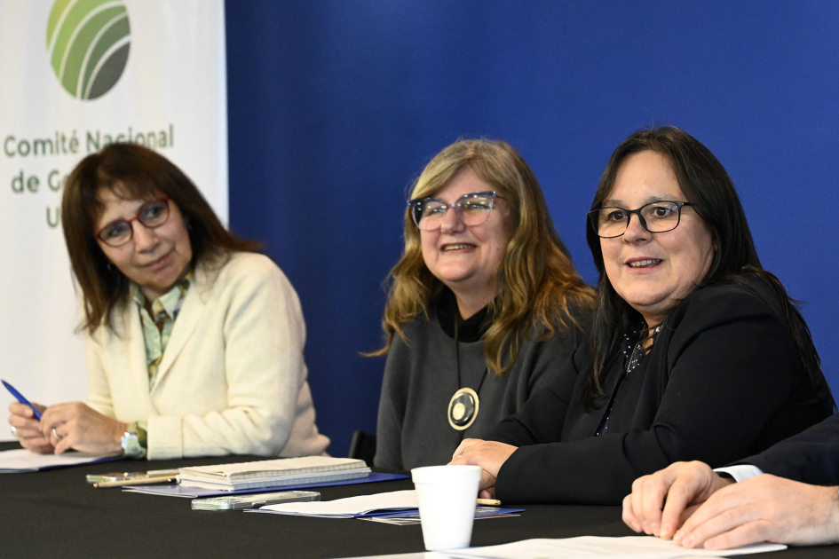 Tres integrantes de la mesa de autoridades, al fondo se puede ser el logo del Comité Nacional 