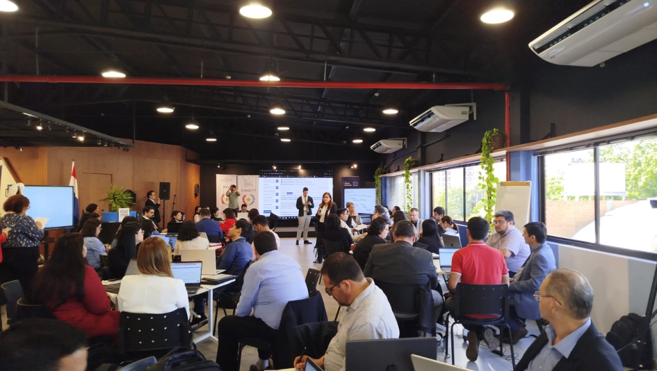 Personas sentadas trabajando en mesas con laptops