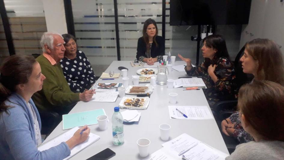El equipo de Educación Inclusiva dialogando con David Towell, Karen Van Rompaey y Matilde (intérprete inglés-español) Personas sentadas en una mesa.