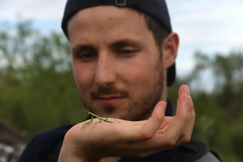 Darwin Leader Hugo Díez Santaolalla observando una mantis religiosa