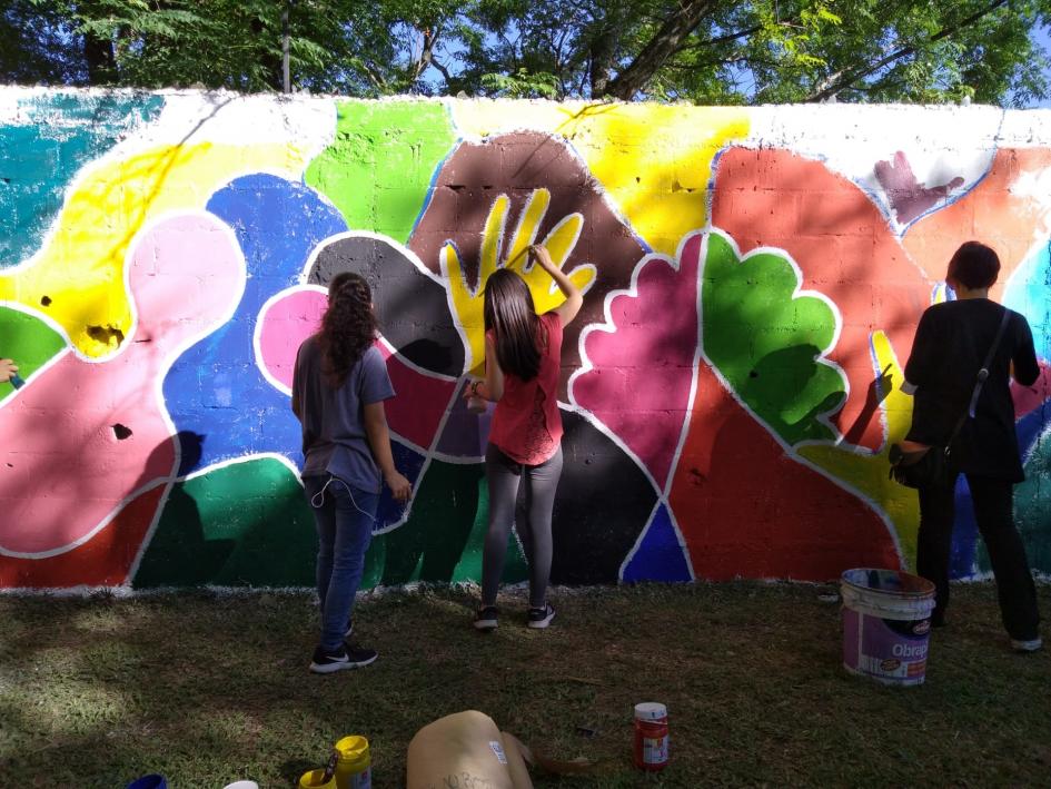 Tres personas pintando el mural.