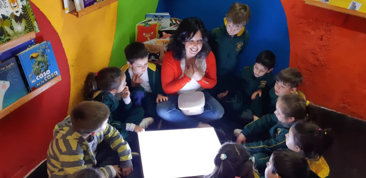 Docente de Espacio de Lectura Pata de Rana junto a niños y niñas compartiendo historiasocente de Esp Docente de Espacio de Lectura Pata de Rana junto a niños y niñas compartiendo historias