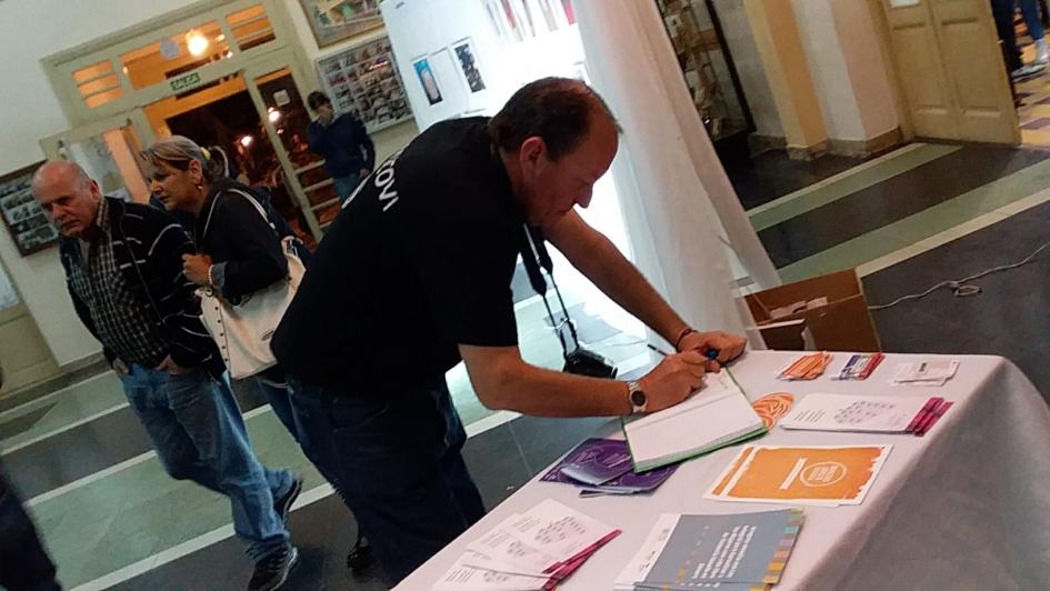 Muestra «Tocó tu piel» Persona escribiendo en cuaderno sobre una mesa