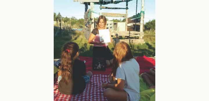 Docente al aire libre leyendo a adolescentes Docente al aire libre leyendo a adolescentes