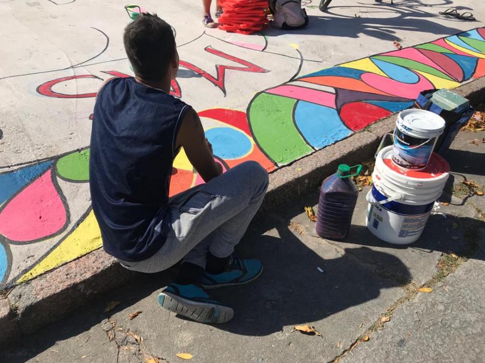 Personas del barrio interviniendo el espacio Persona pintando una vereda