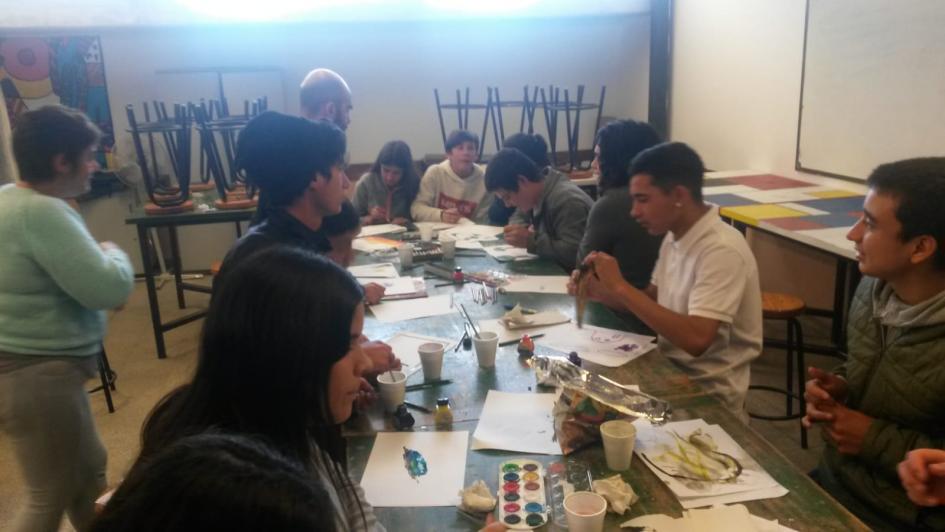 grupo de adolescentes de durazno pintando y dibujando alrededor de una mesa