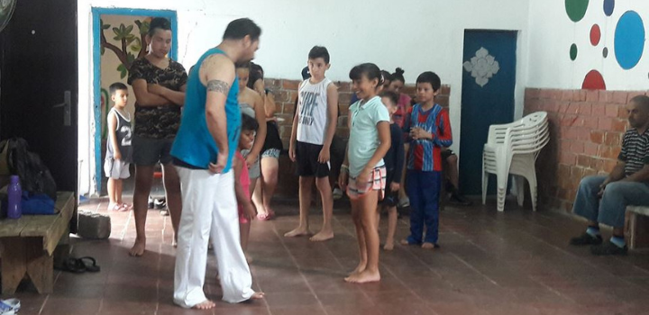 Docente de taller de capoeira junto a participantes del taller Docente de taller de capoeira junto a participantes del taller