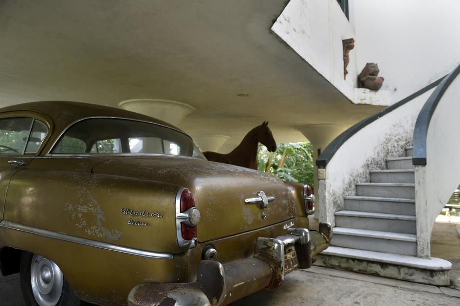 Primer plano del auto y de fondo se ve la escalera del chalet