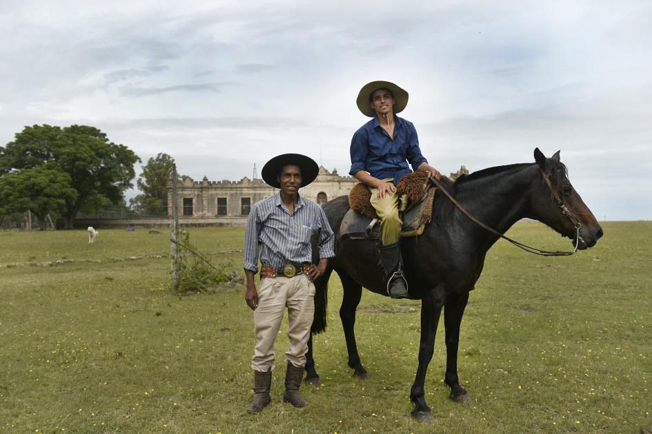 Un hombre a caballo y otro parado