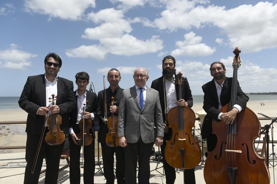 Integrantes del Quinteto de cuerdas de Maldonado con sus instrumentos y en el medio el ministro