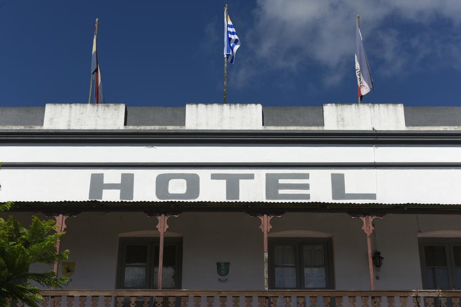 Viste de arriba del hotel que dice "Hotel" y arriba se ven tres banderas patrias