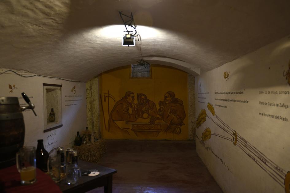Vista general de la cervecería y atrás se ve la pintura de tres monjes