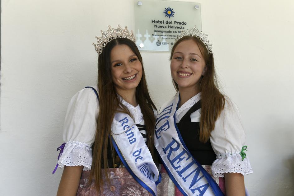 Dos mujeres representado a las reinas de Nueva Helvecia con la placa atrás