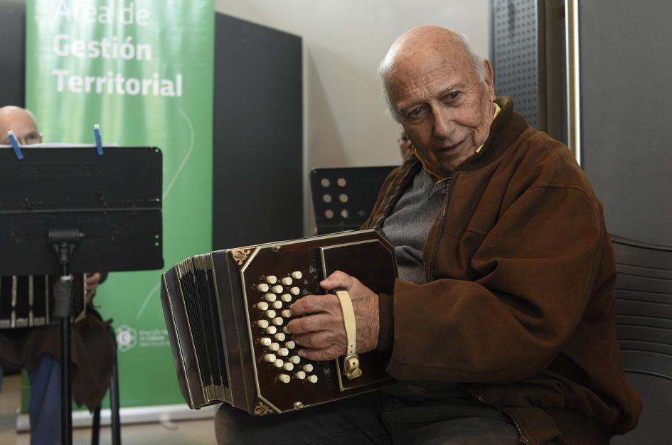 Hombre sentado y tocando el acordeón