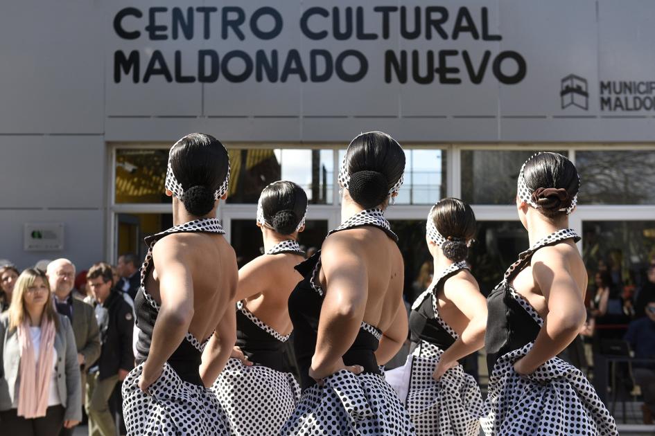 Mujeres vestidas de época bailando de espalda