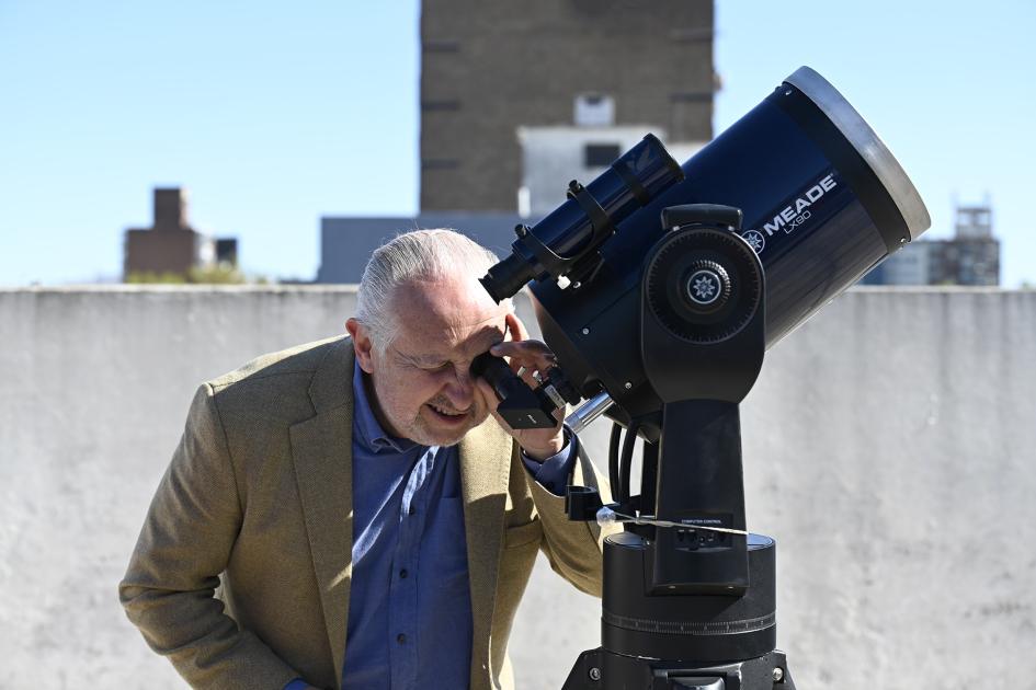 Persona mirando por telescopio.
