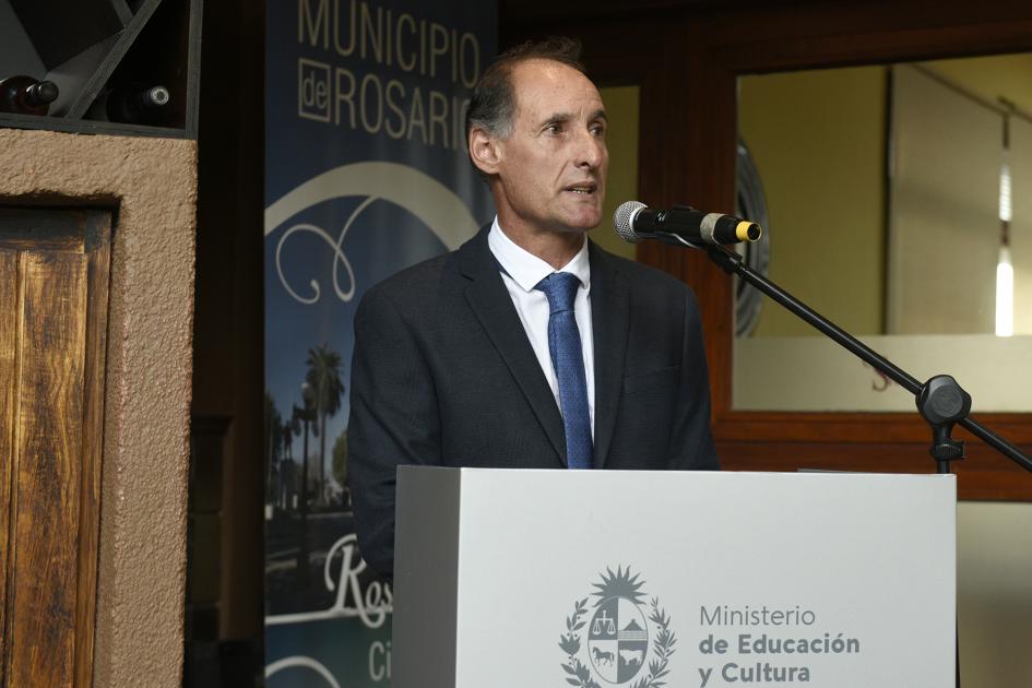 Hombre de traje y corbata hablando atrás de un atril