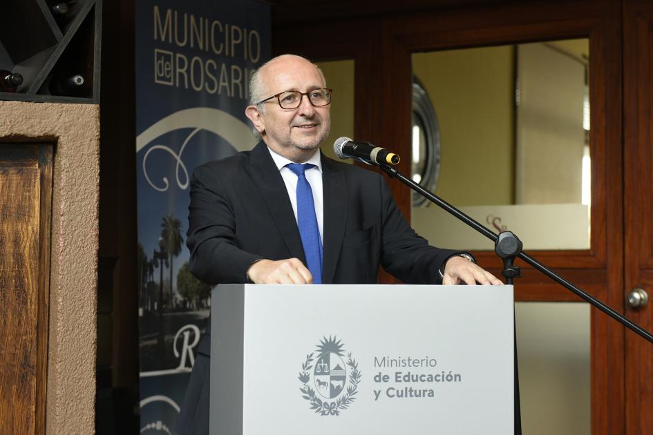 Hombre de lentes sonriendo y hablando