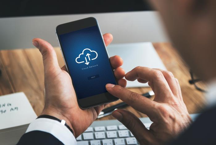Primer plano de hombre de negocios con smartphone con símbolo de computación en la nube