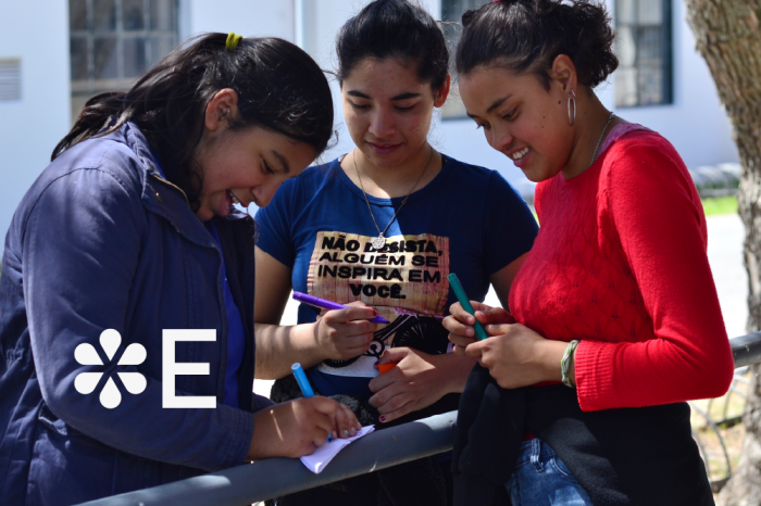 Convocatoria 2023 de la Beca Educación Media Pública Tres personas en ronda escribiendo en una hoja