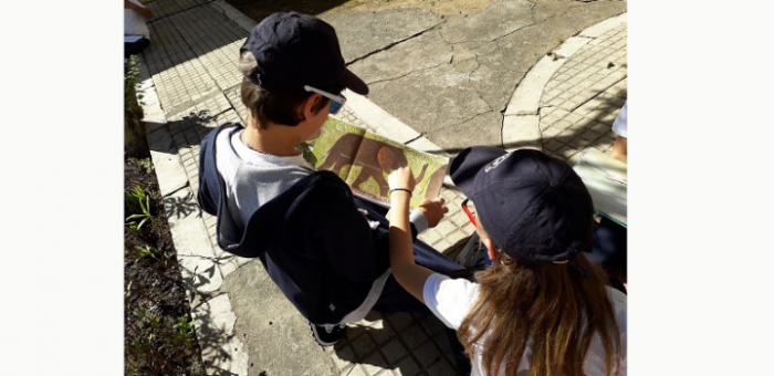 niño y niña leyendo un libro al aire libre