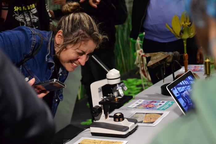 Mujer mirando a través de un microscopio