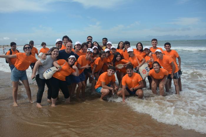 Personas posando para una foto en la vera del mar