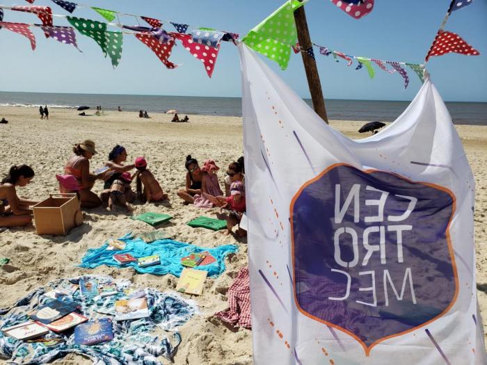 Bandera de Centros MEC y de fondo niños, niñas y jóvenes en la playa Bandera de Centros MEC y de fondo niños, niñas y jóvenes en la playa
