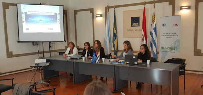 Mesa expositora Personas sentadas atrás de la mesa