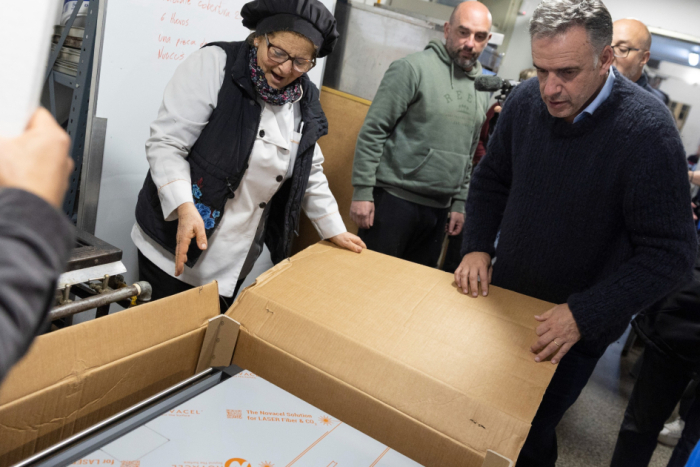 Taller de panadería de Cecap Brazo Oriental recibió horno prometido por Orsi Personas sacando un horno de una caja