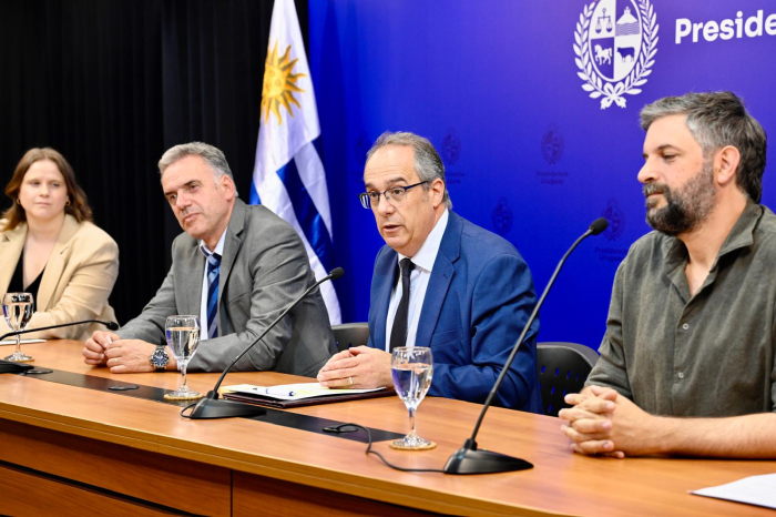Personas en mesa hablando al público.