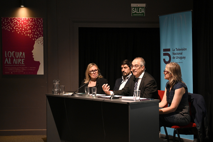 Personas en mesa hablando al público