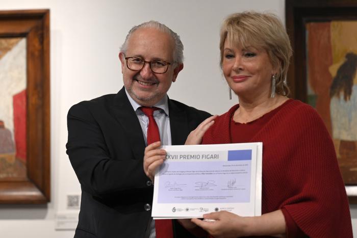 Pilar González sosteniendo el certificado junto al ministro.