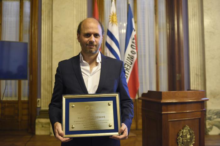 Gustavo Casenave parado y mostrando la placa