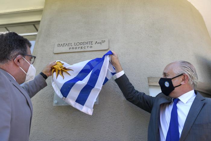 Dos hombres sacando la bandera de Uruguay para descubrir la placa