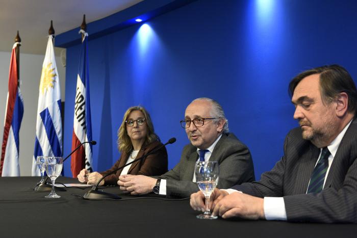 Personas en mesa y de fondo pabellones patrios