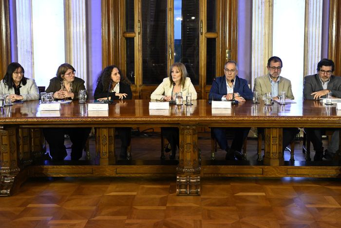Personas en mesa hablando al público